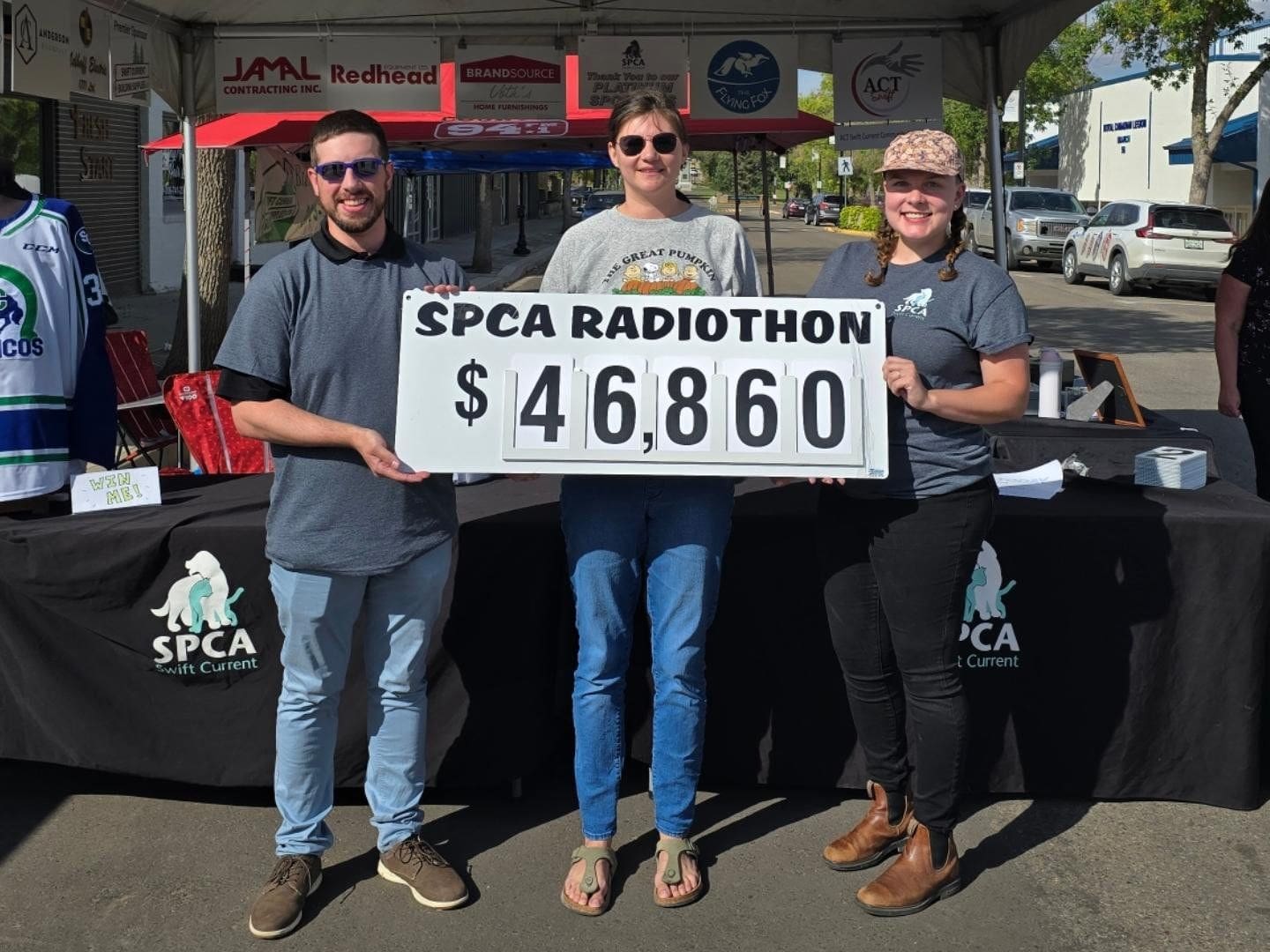 David Zammit, Marissa Wolfe, and Kate Andriushyn pose with the grand total for the 2024 Radiothon, $46,860.